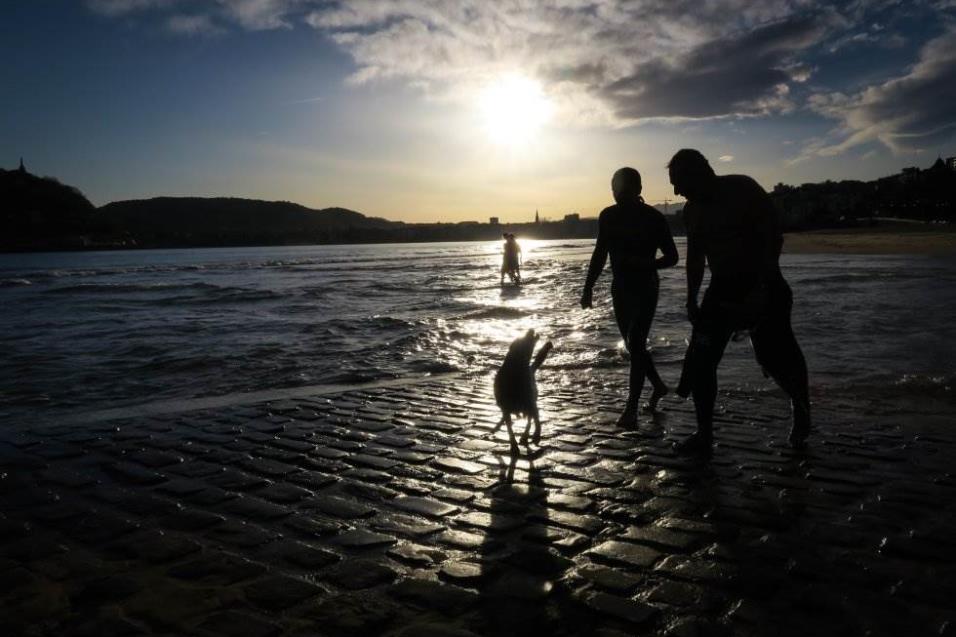 Un perro pasea con sus dueños en la playa de Ondarreta de San Sebastián (España), el 6 de abril de 2018. JAVIER ETXEZARRETA EFE