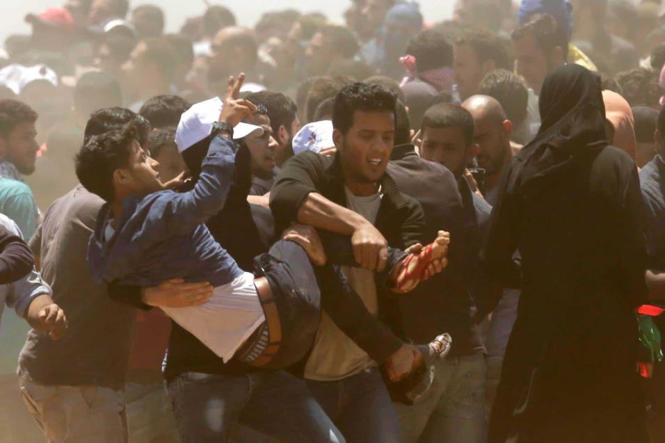 Palestinos trasladan a un herido durante los choques en la franja de Gaza, el 14 de mayo de 2018. MAHMUD HAMS AFP