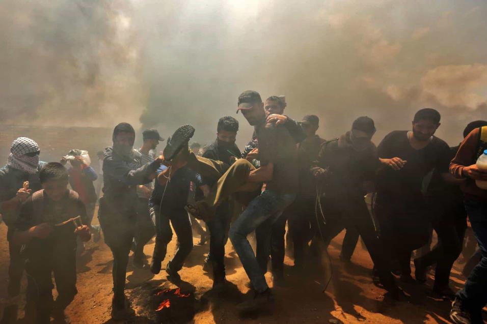 Palestinos trasladan a un herido durante los choques en la franja de Gaza, el 14 de mayo de 2018. MAHMUD HAMS AFP