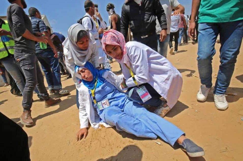 Una mujer médico atiende a una compañera herida durante los enfrentamientos con el ejército israelí al este de Khan Yunis, en la Franja de Gaza. SAID KHATIB AFP