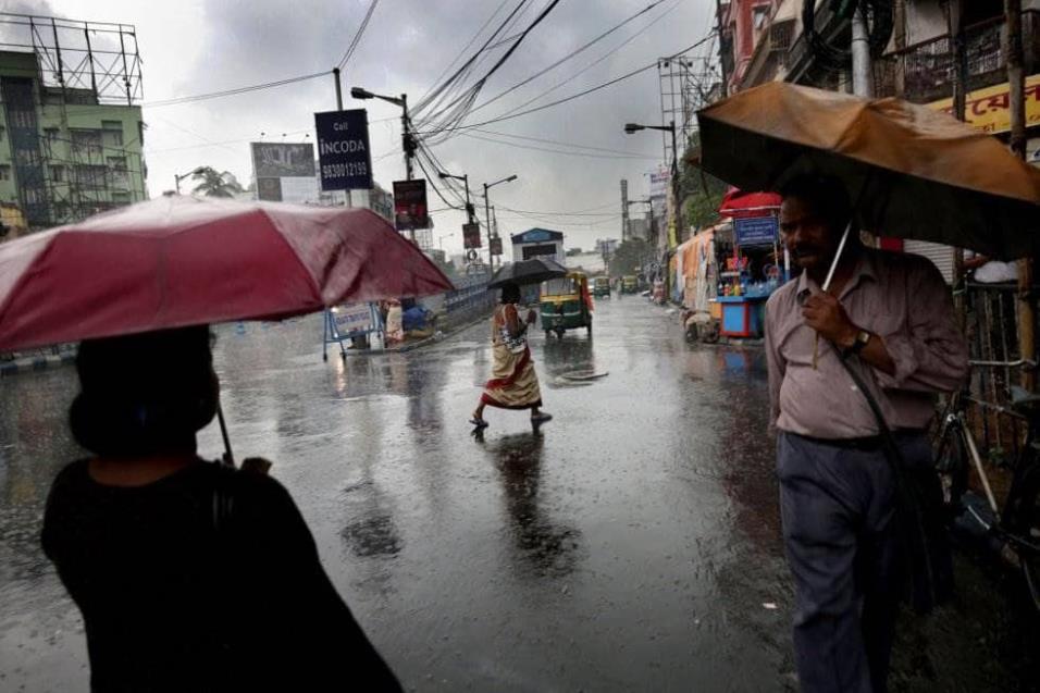 Varias personas caminan bajo la fuerte lluvia, en Calcuta (India). PIYAL ADHIKARY EFE