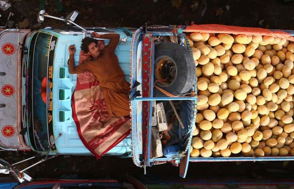 Un vendedor se echa una siesta en su furgoneta donde vende melones en un mercado en Karachi (Pakistán). SHAHZAIB AKBER EFE