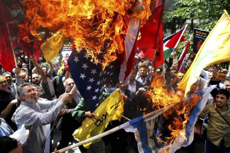 Iraníes queman las banderas de Israel y Estados Unidos durante una protesta dentro de la antigua embajada estadounidense, en Teherán (Irán). EBRAHIM NOROOZI AP