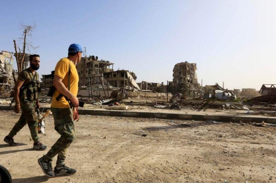 Miembros de las fuerzas del gobierno sirio caminan por una calle destrozada de al-Hajar al-Aswad, en las afueras de Damasco, el 21 de mayo de 2018. LOUAI BESHARA AFP