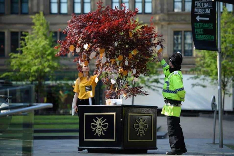 Un agente de policía se acerca al árbol de la esperanza, donde numerosas personas han dejado mensajes en recuerdo a las víctimas de la tragedia del 22 de mayo de 2017 en Manchester cuando 22 personas murieron tras un atentado al salir de un concierto de