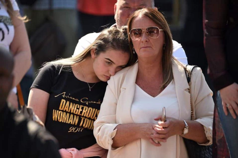 Una mujer con la camiseta de Ariana Grande reacciona frente a la Catedral de Manchester. OLI SCARFF AFP