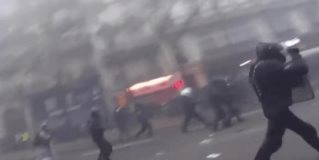 Dos policías golpean a manifestante en el suelo durante la huelga general en París