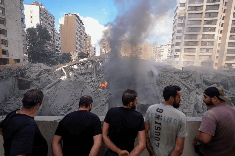 Varias personas contemplan los daños causados en un edificio tras un bombardeo israelí sobre Beirut, este miércoles.