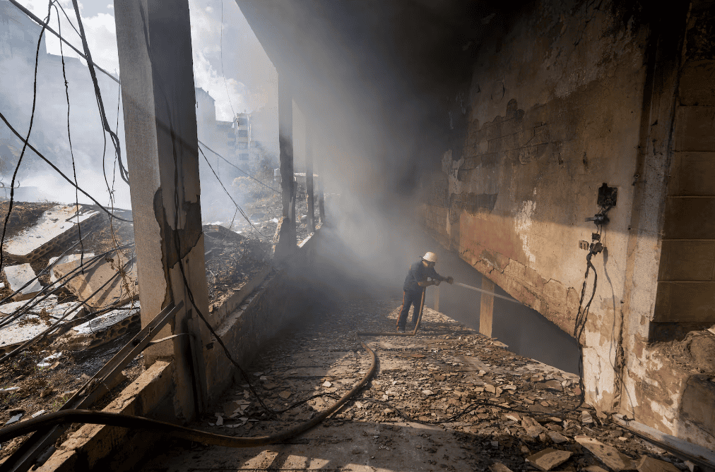 Un bombero apaga las llamas de un edificio afectado por un bombardeo en el barrio de Dahiyeh en Beirut, este miércoles.