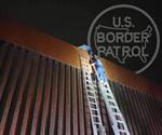 Rescatan migrante trepado en el muro