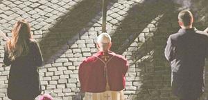 El papa León XIV carga la cruz en el víacrucis