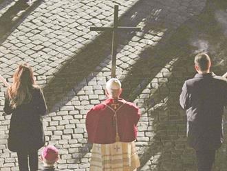 El papa León XIV carga la cruz en el víacrucis