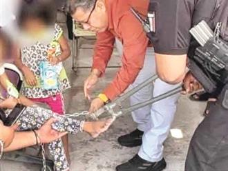 Atan a dos niñas con cadenas y candados