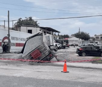 Cae camión de volteo, cargado de grava en enorme socavón