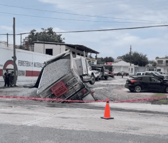 Cae camión de volteo, cargado de grava en enorme socavón