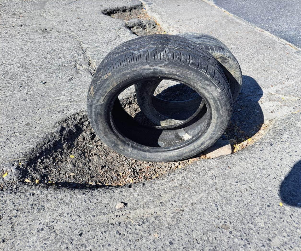 Vecinos señalizan baches con llantas